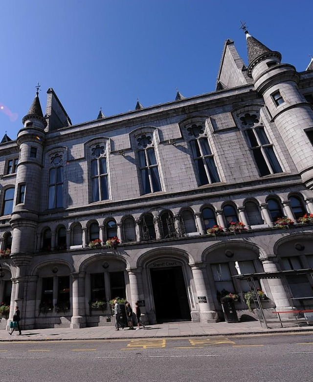 A solicitor and consultant cardiologist discuss a medico-legal case in a professional setting, aligning on report requirements for an Aberdeen cardiology expert witness instruction.